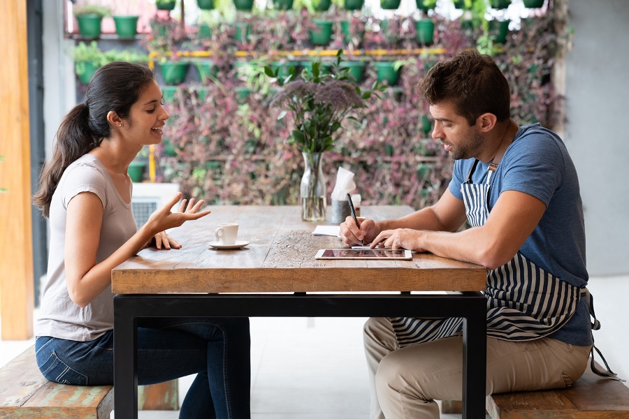 Portrait of a woman at a job interview for a restaurant talking to the manager and looking happy - food service occupation concepts