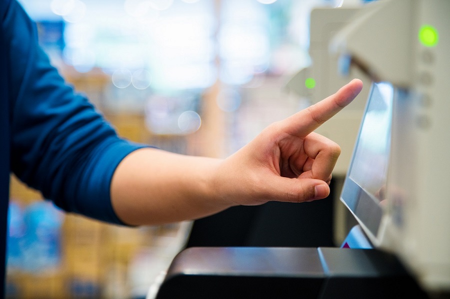 Close up of a woman's hand as she uses a self checkout machine. Osaka, Japan. June 2016
