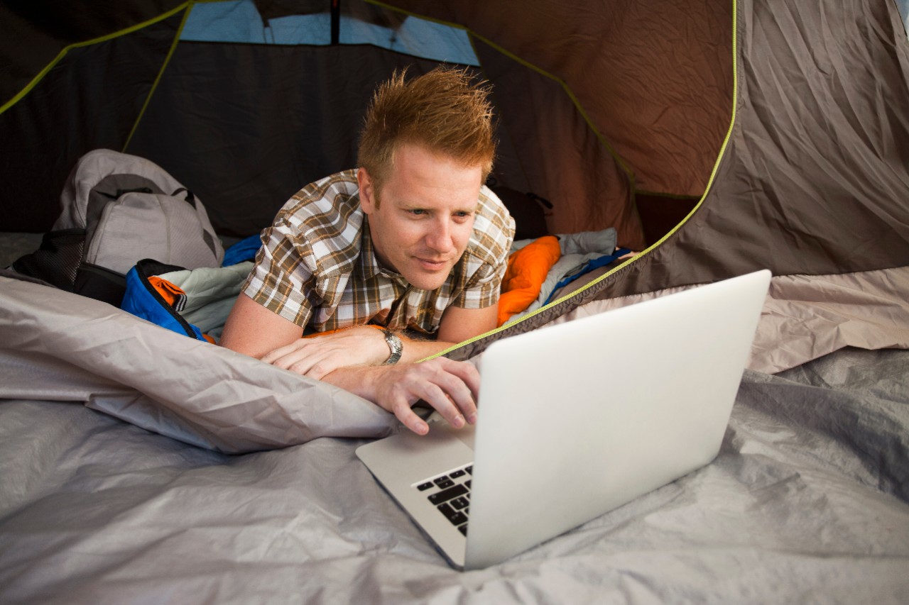 Man male boy using laptop outside in a digital globally connected world