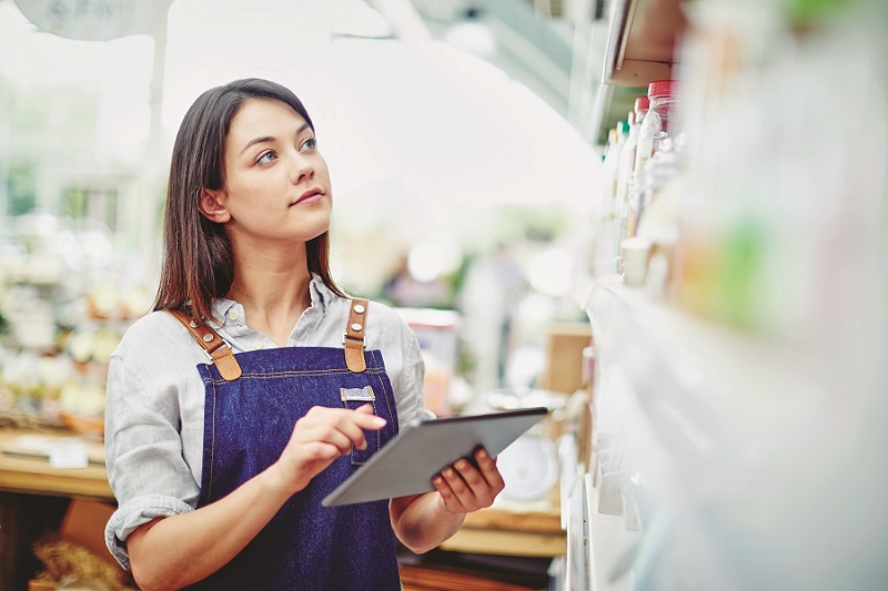 a woman holding a tablet checking data in a retal store