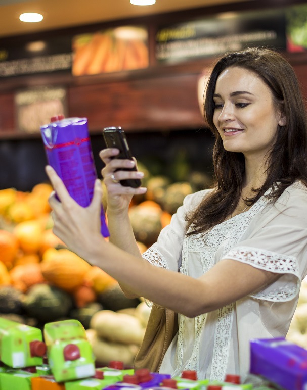 woman shopping and taking a photograph with cellphone of products