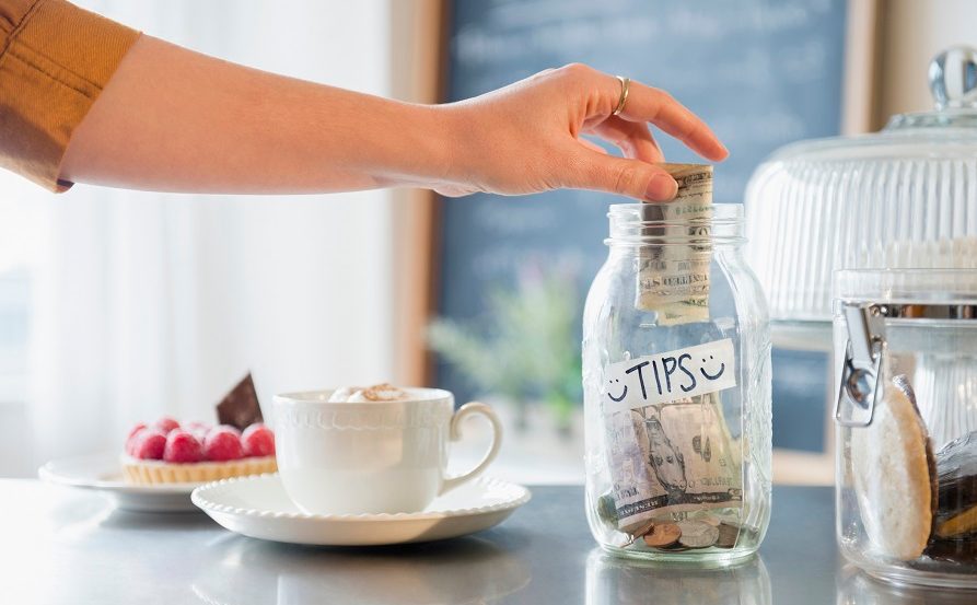 Caucasian woman putting money in tip jar