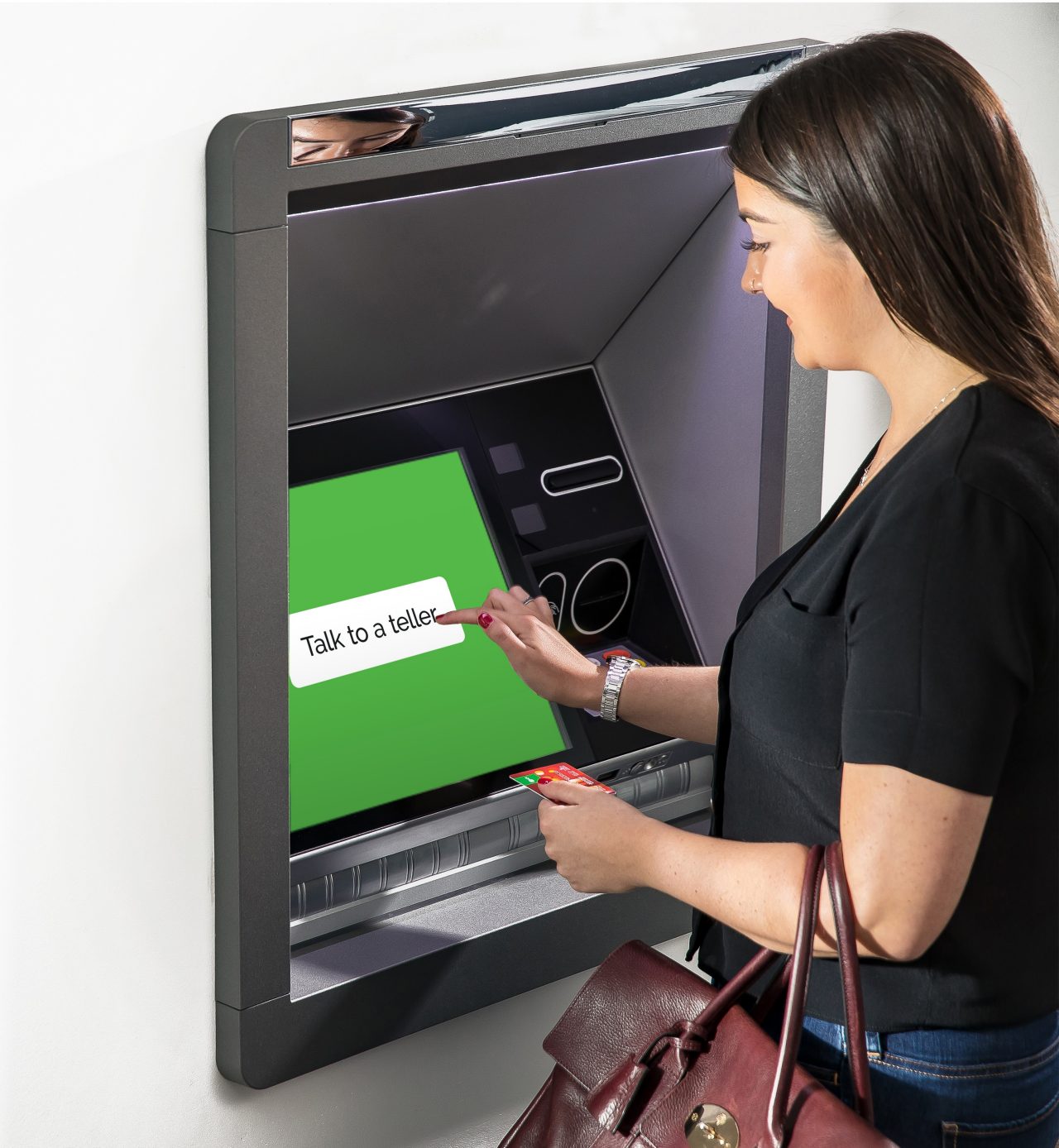 A young woman using an Interactive Teller machine